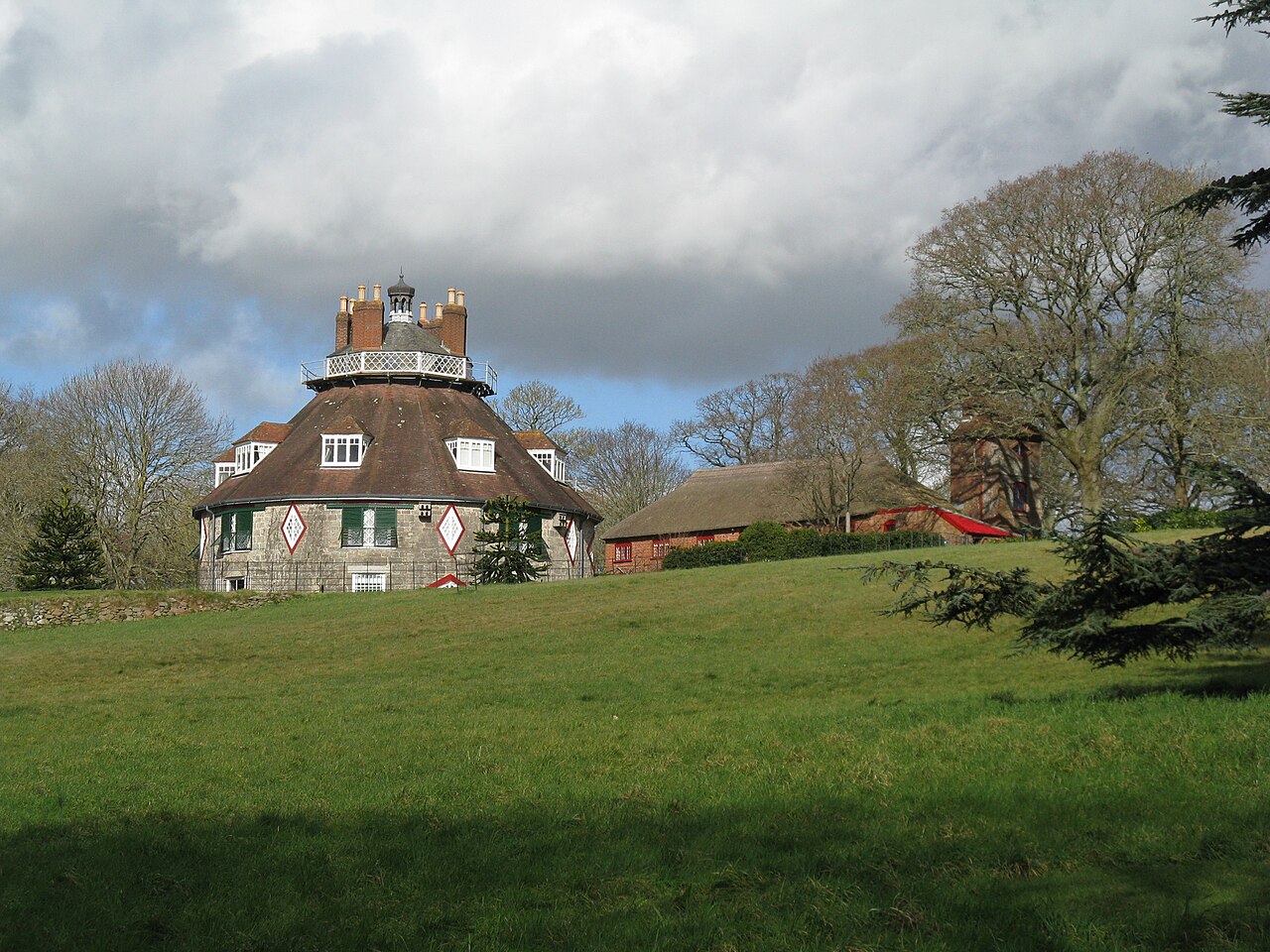The many-sided A la Ronde house and steep roof above its Devon lawn