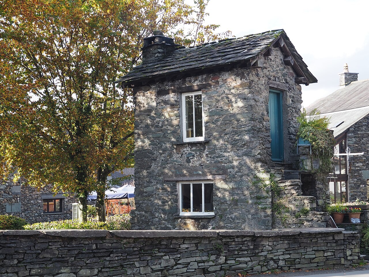 Small stone Bridge House with its windows and slate roof in Ambleside