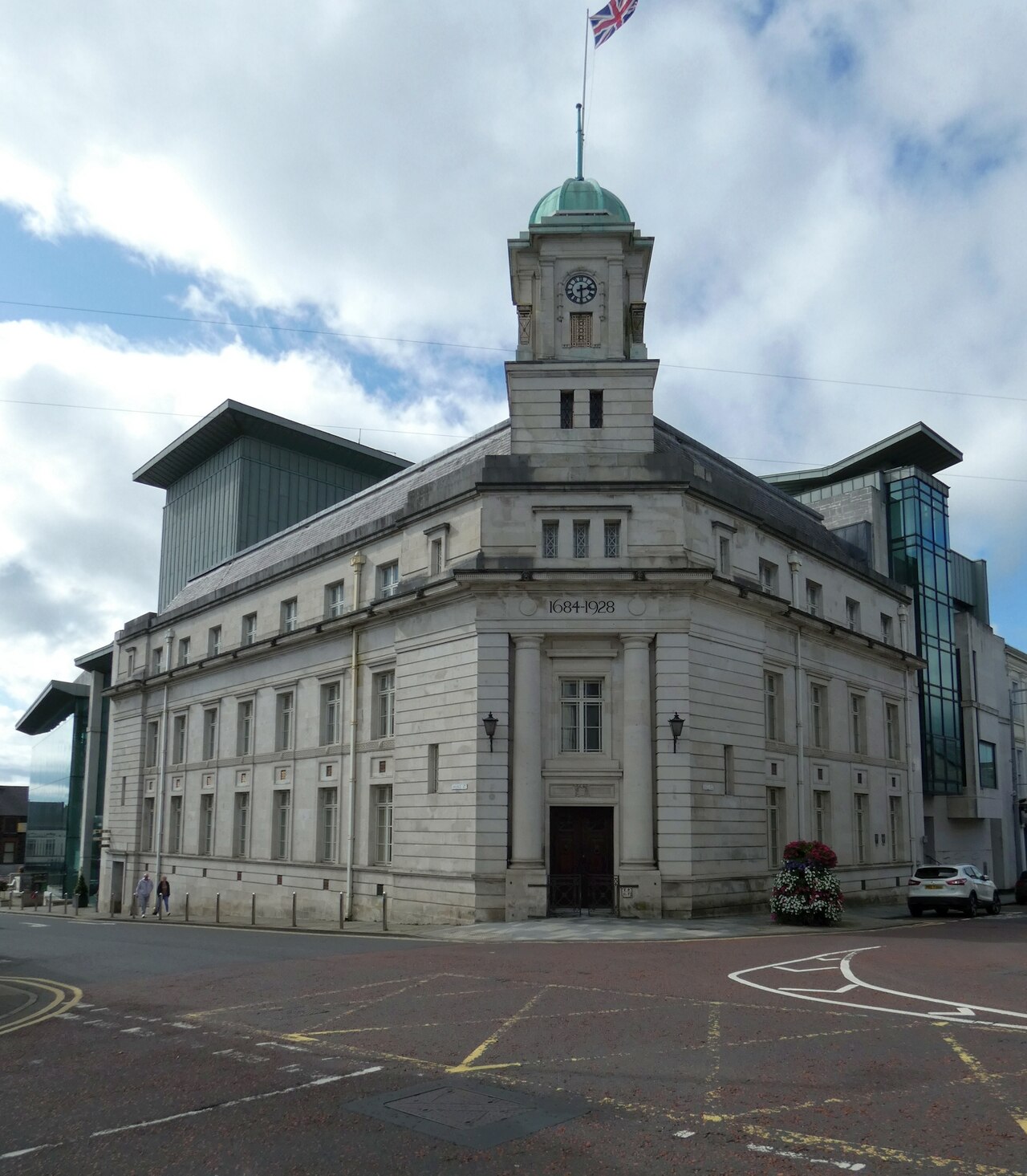 Ballymena Town Hall clock tower and stone facades beside the modern Braid building