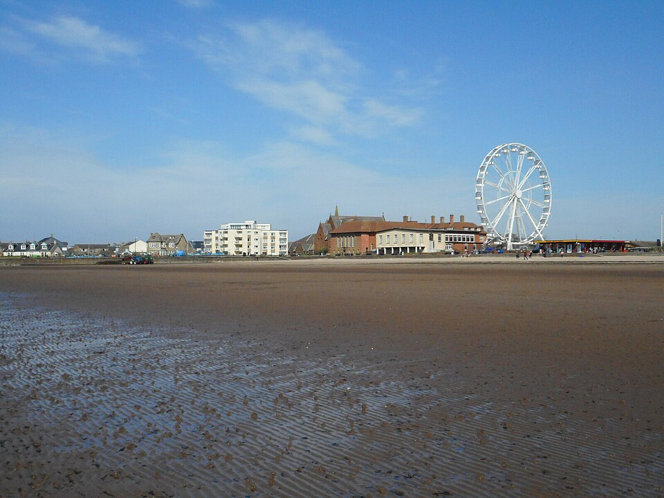 Troon South Beach at low tide, with seafront buildings and a fairground wheel in this archive view.