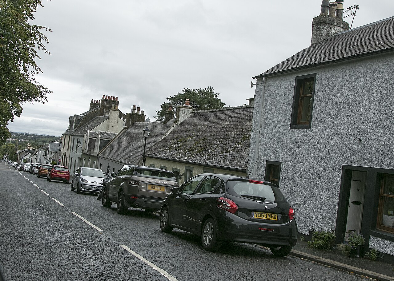 Stone cottages and parked cars along a street in Eaglesham