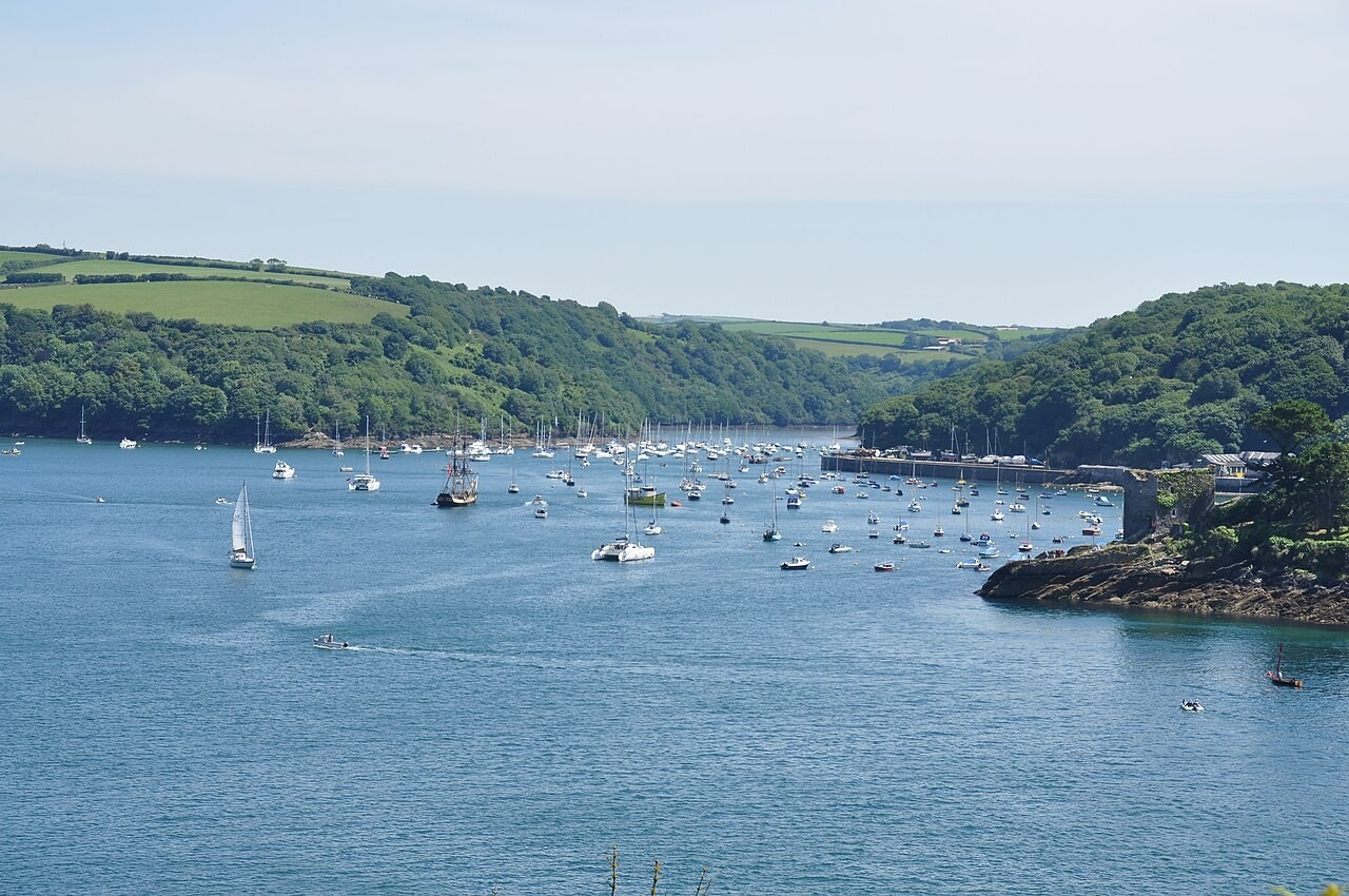 Sailing boats in the Fowey Estuary beneath wooded hills