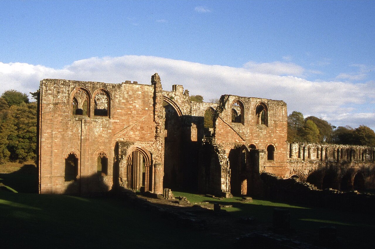 Red sandstone remains of Furness Abbey in afternoon light