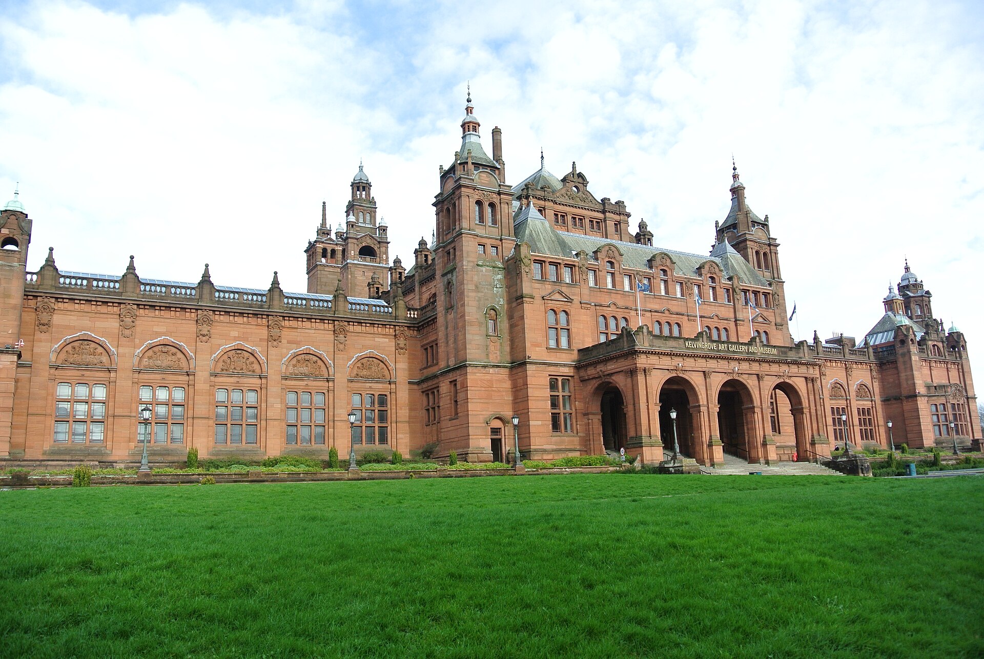 Kelvingrove’s red sandstone galleries and towers beyond a green lawn