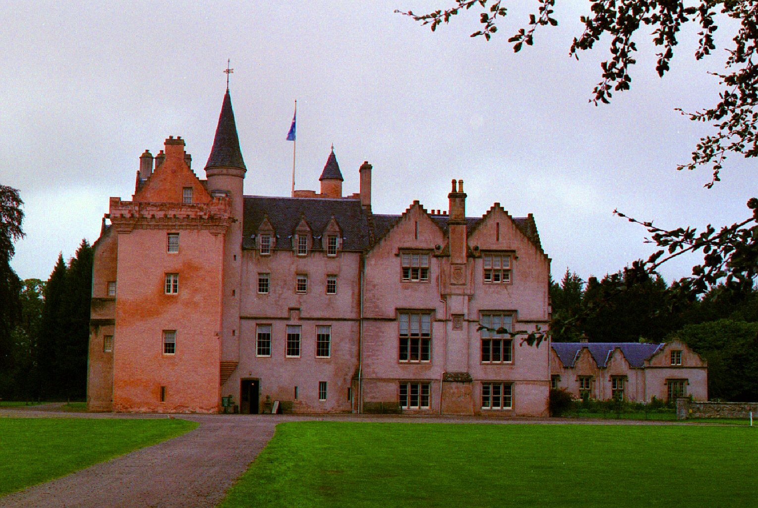 Rose-coloured Brodie Castle with turrets and lawn in Moray