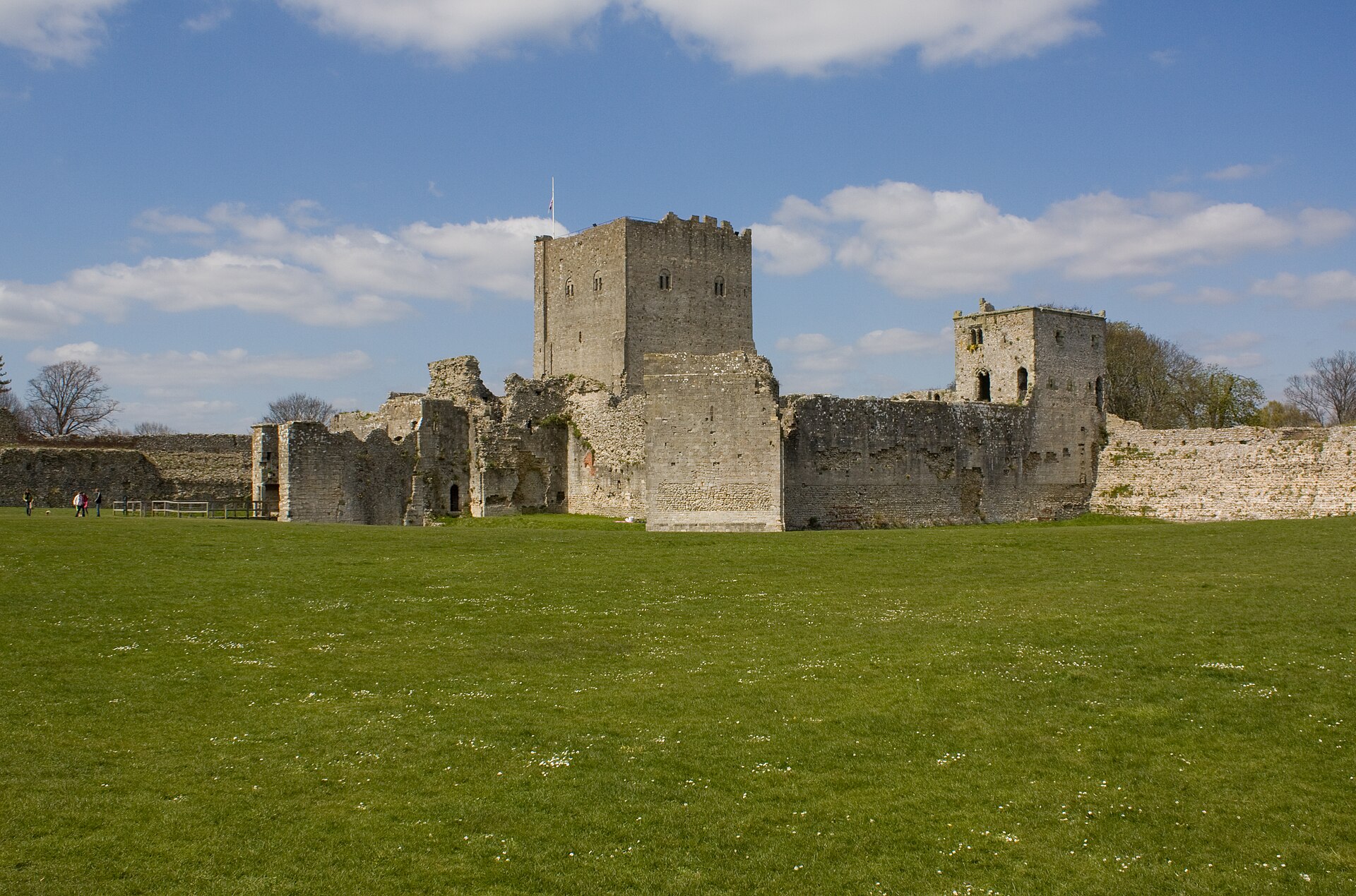 Portchester Castle keep and curtain walls beyond the green Roman fort enclosure