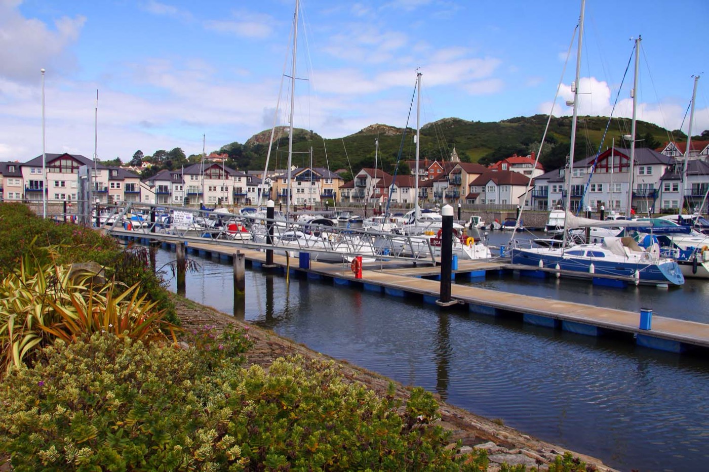Boats in Deganwy Quay Marina with waterfront buildings and hills behind