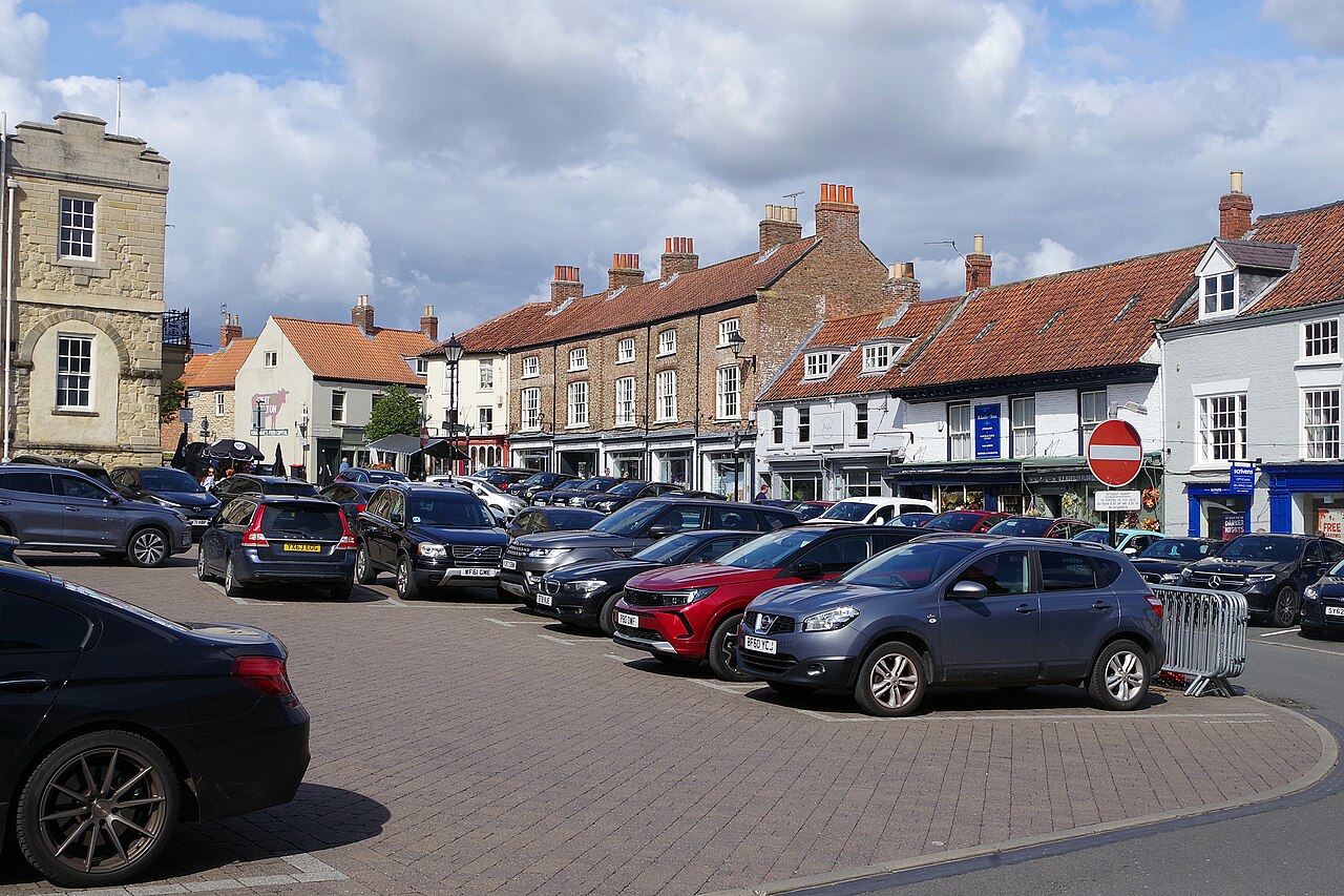 Historic buildings and parked cars around Market Place in Malton