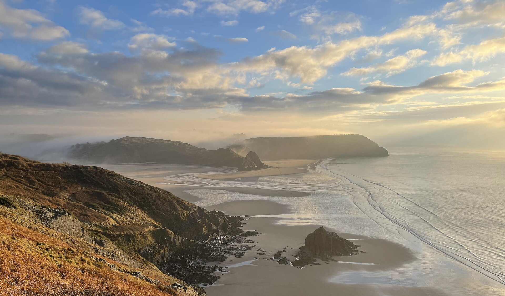 Morning light over Three Cliffs Bay and its tidal sands