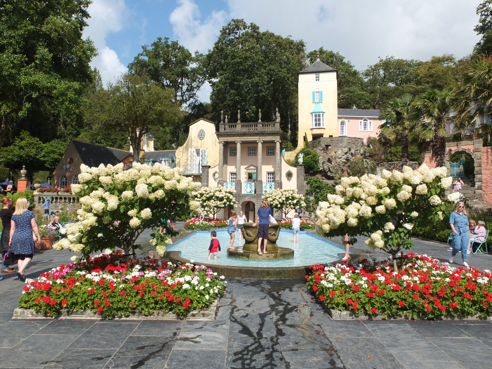Portmeirion’s Central Piazza with a fountain, flowers and colourful buildings