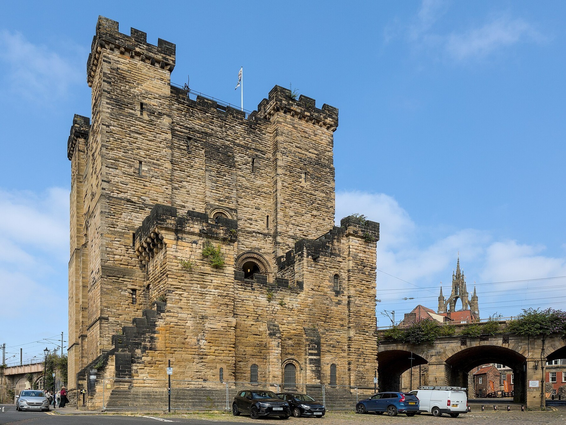 The stone Castle Keep beside the railway viaduct in Newcastle, with the cathedral tower beyond