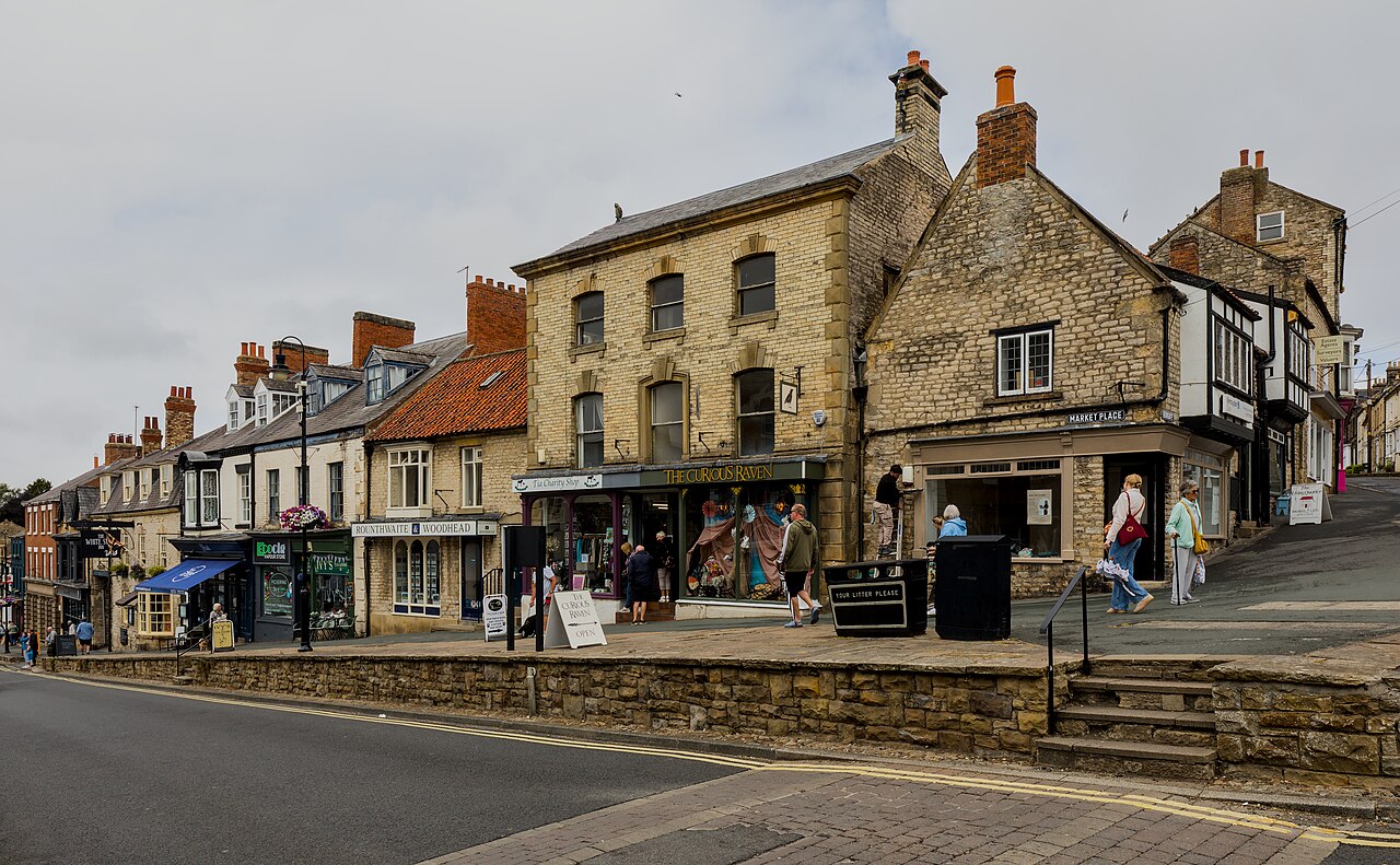 Stone shops and raised pavement beside Pickering Market Place