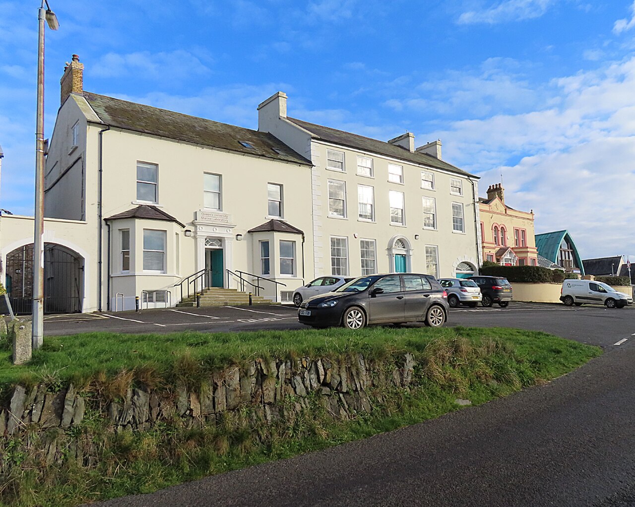 Pale waterfront buildings and stone retaining wall in Portaferry
