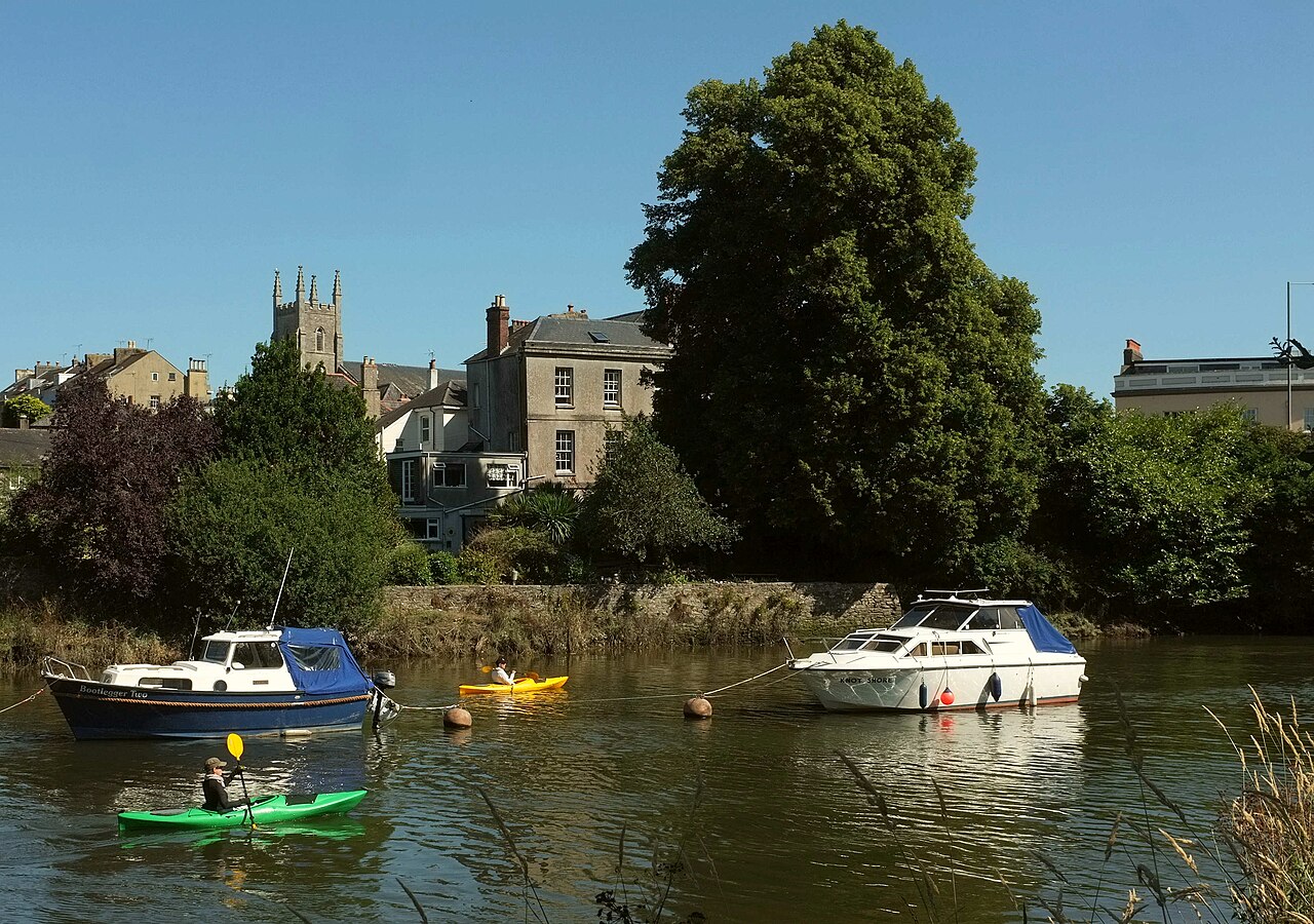 Boats and kayaks on the River Dart below Totnes town