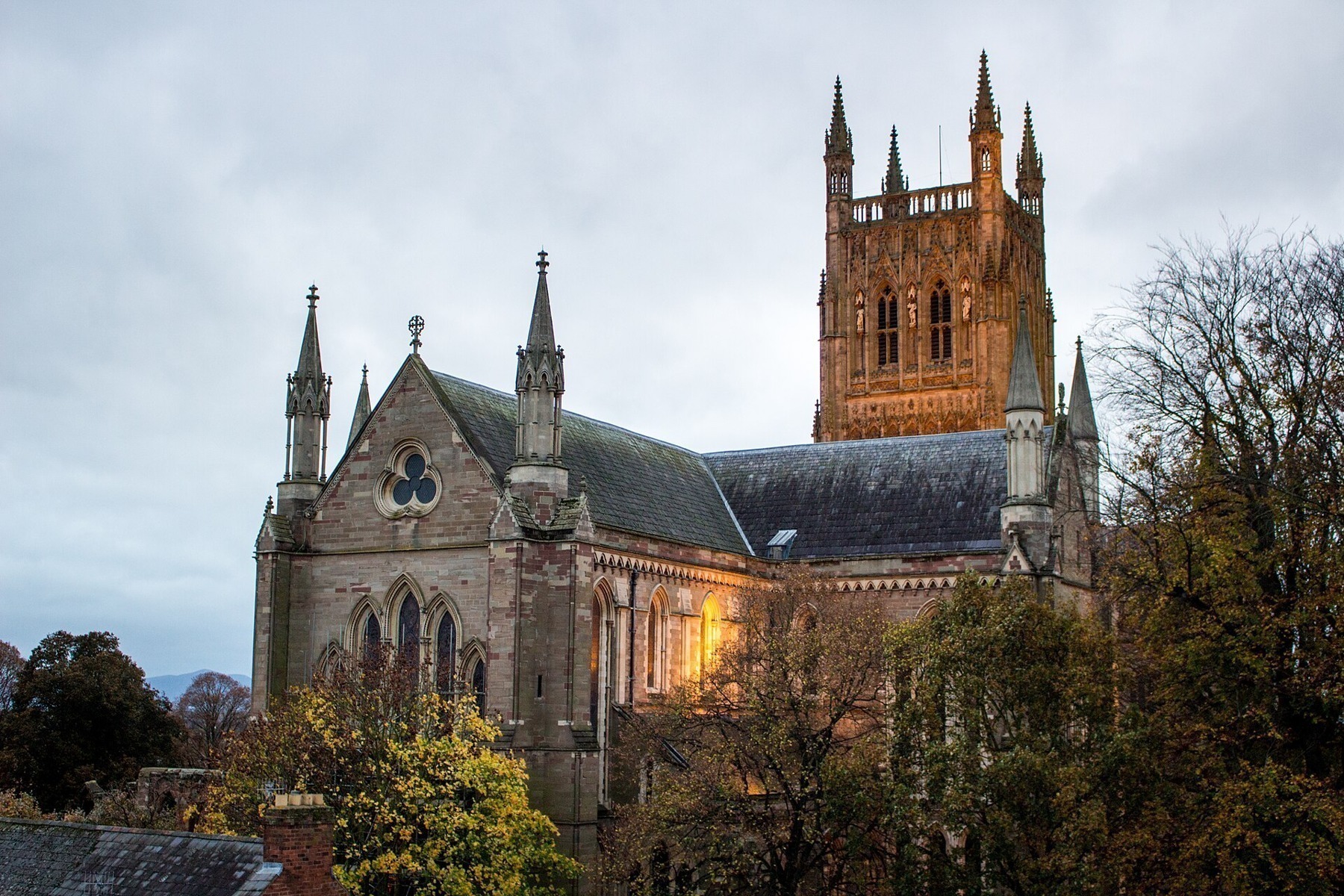 Worcester Cathedral and its square tower lit against an evening sky